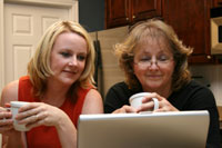 mother and daughter look at laptop