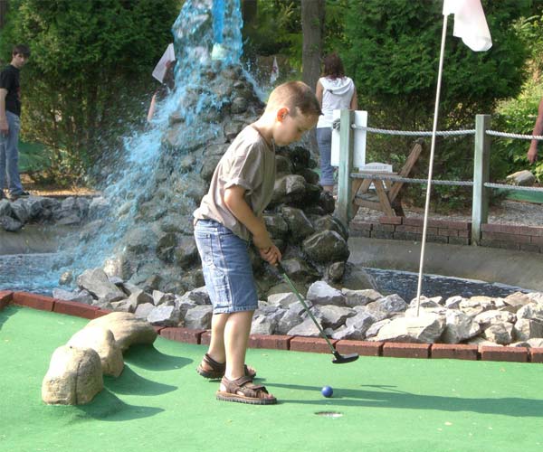 kid playing mini golf