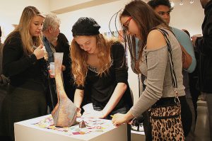 Gallery visitors at the 2016 Juried Student Exhibition with Mercury Hogan's interactive piece, Catharsis.