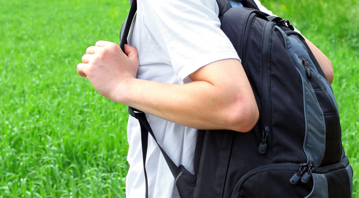close up of a kid carrying a dark backpack
