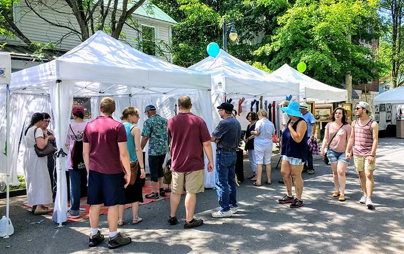 people browsing vendors at an arts and crafts fair
