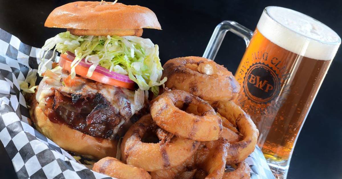 bbq sandwich with onion rings and a glass of beer