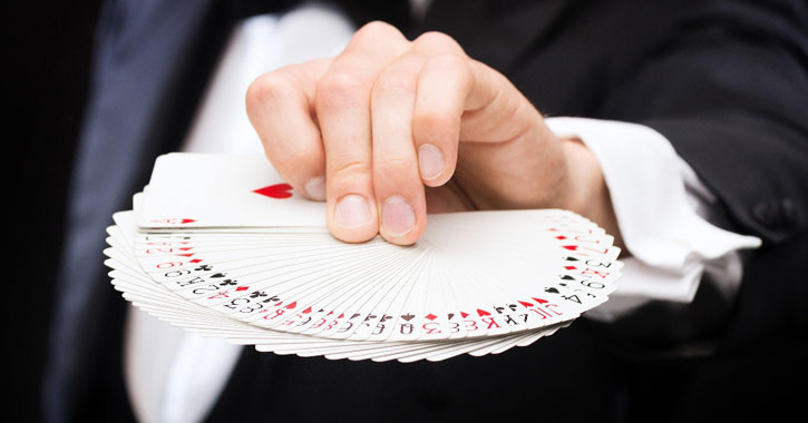 a magician's hand fanning out a deck of cards