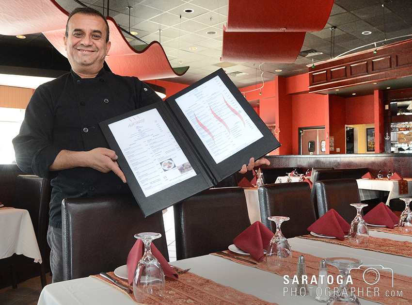 Rauf Ziya, owner of Alaturco Mediterranean Grill in Clifton Park, displays his menu of largely Turkish dishes at the establishment he opened in Clifton Park Center on Clifton Country Road. ©2017 Saratoga Photographer.com